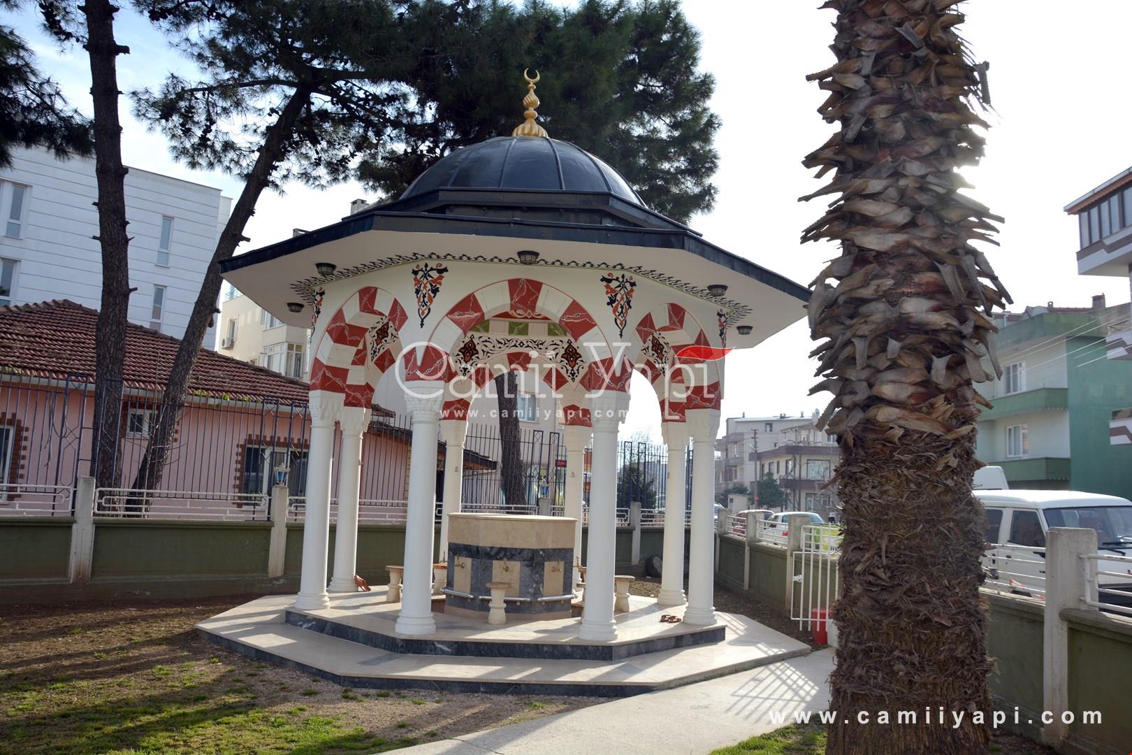 ablution fountain with stone columns and surrounding trees