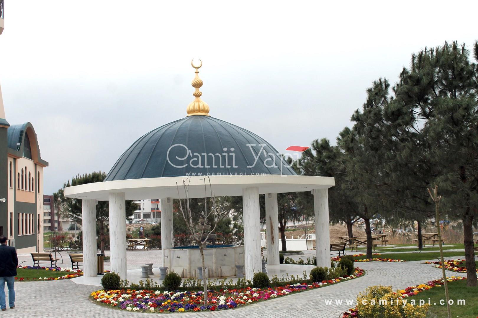 Round ablution fountain next to the green area