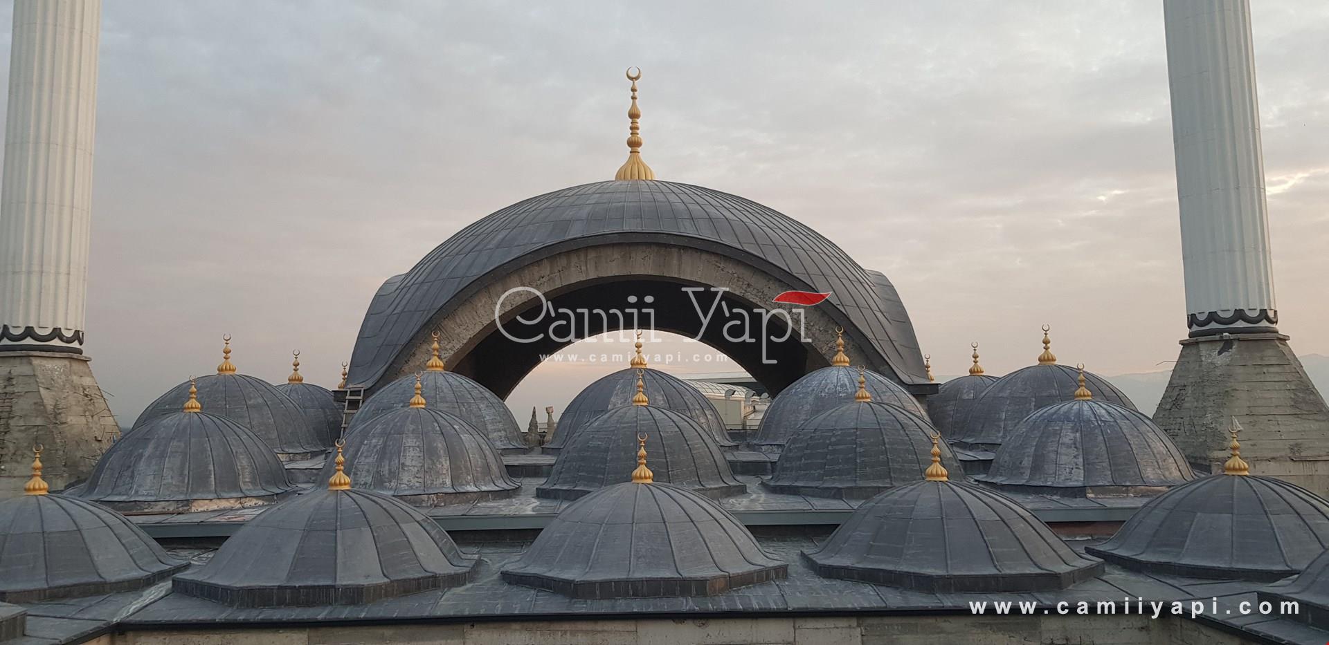 Kubbe üzerindeki metal alem ve cami cephesi