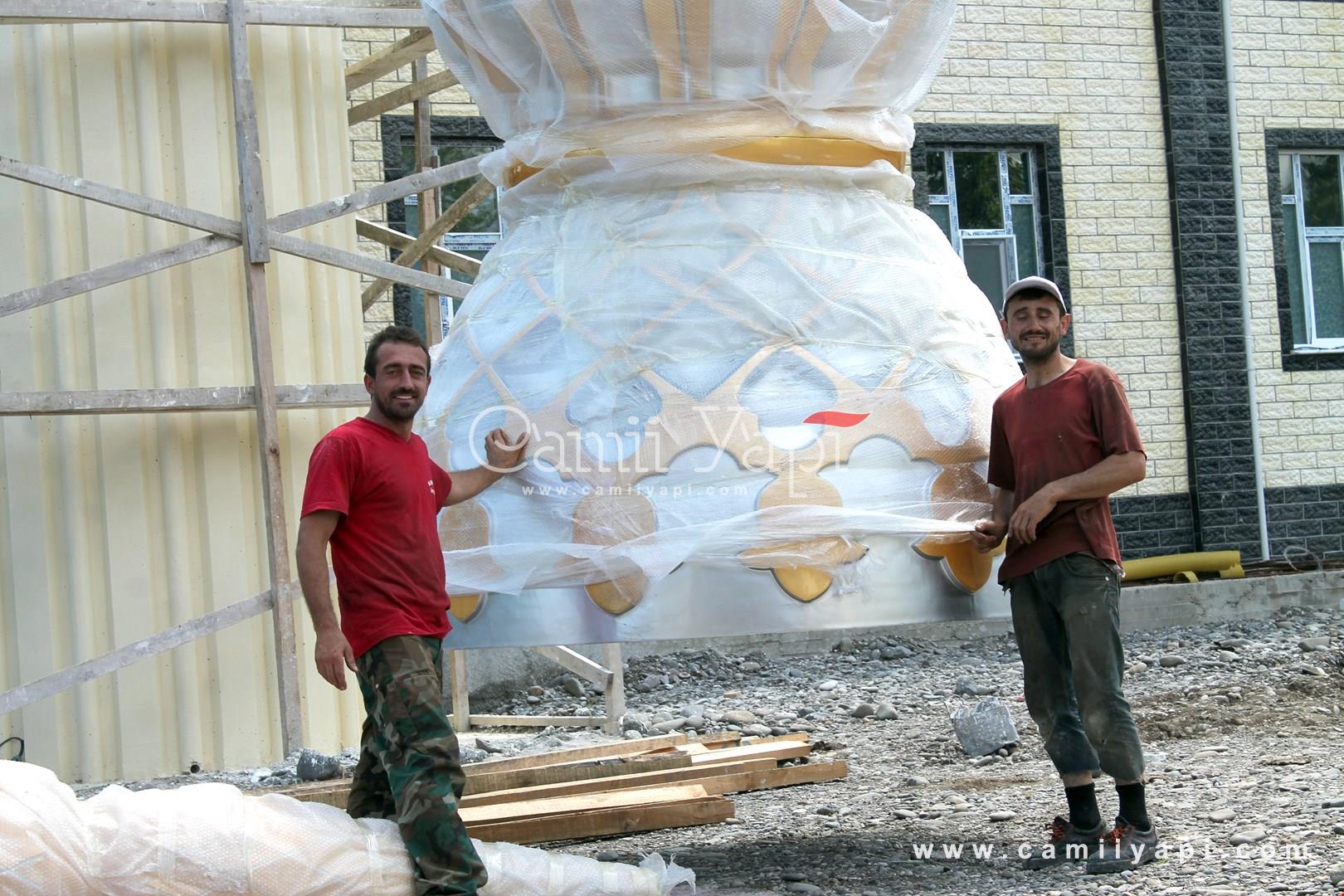 Paketlenmiş metal kubbe alemi hazırlayan iki kişi